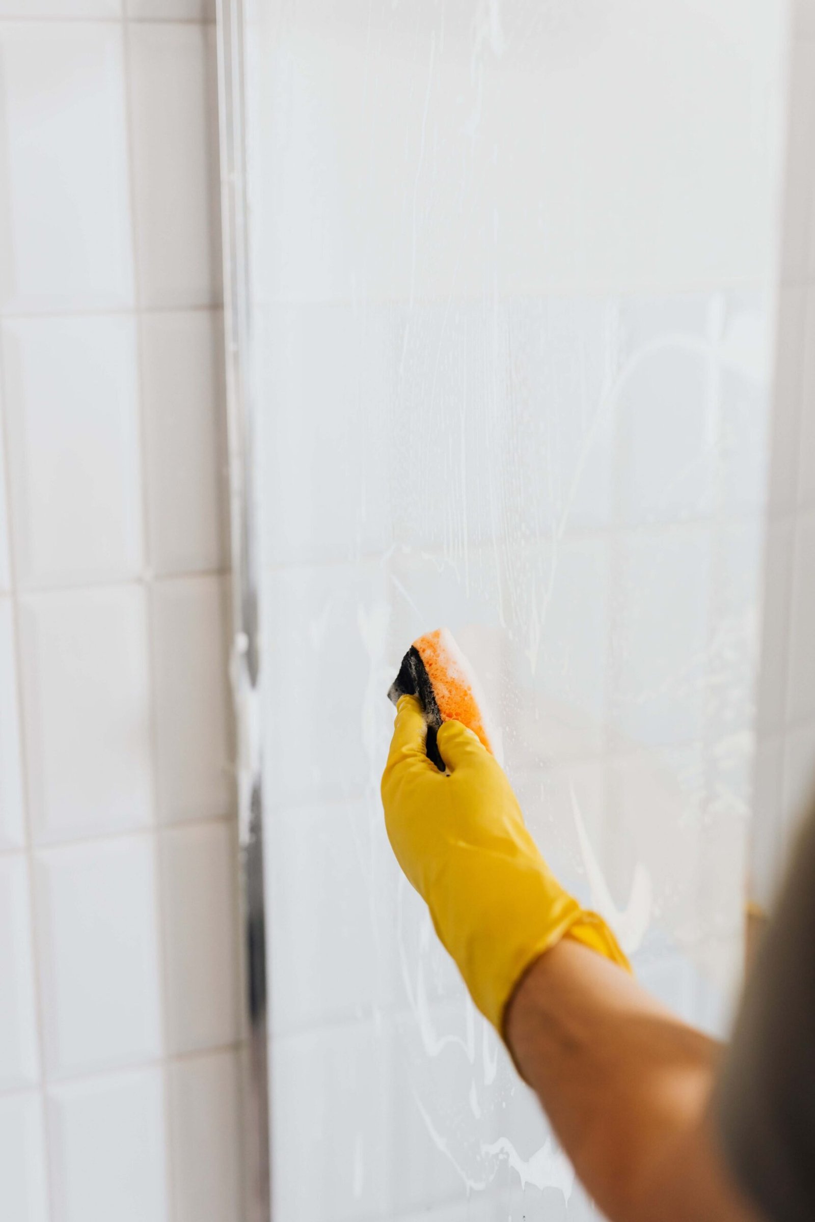Cleaner scrubbing a shower glass